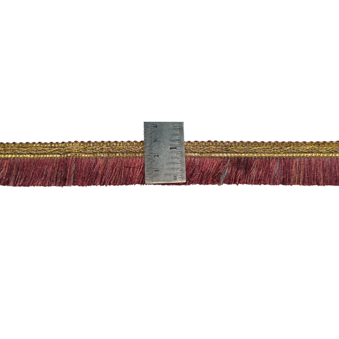 Textured ribbon with fringe and a ruler for scale on a white background